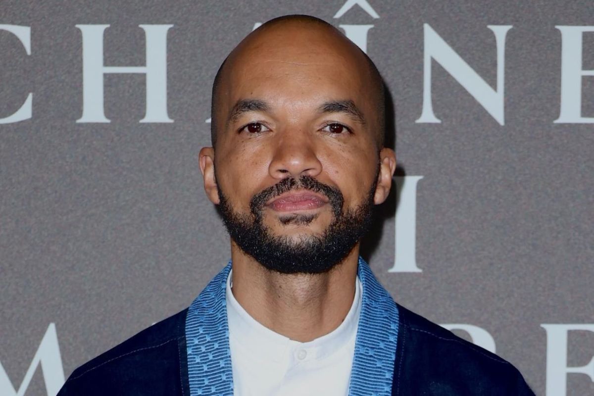 A man in a blue jacket is seen staring directly into the camera.